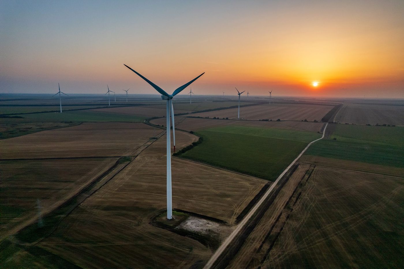 Wind turbines on rolling hills under a clear sky
