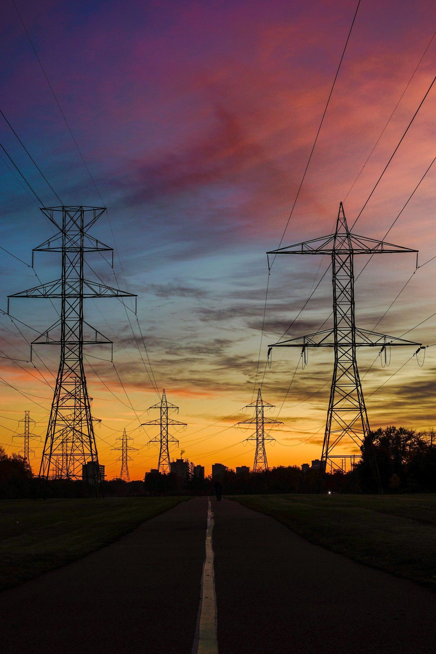 Transmission towers silhouetted against a golden sunset